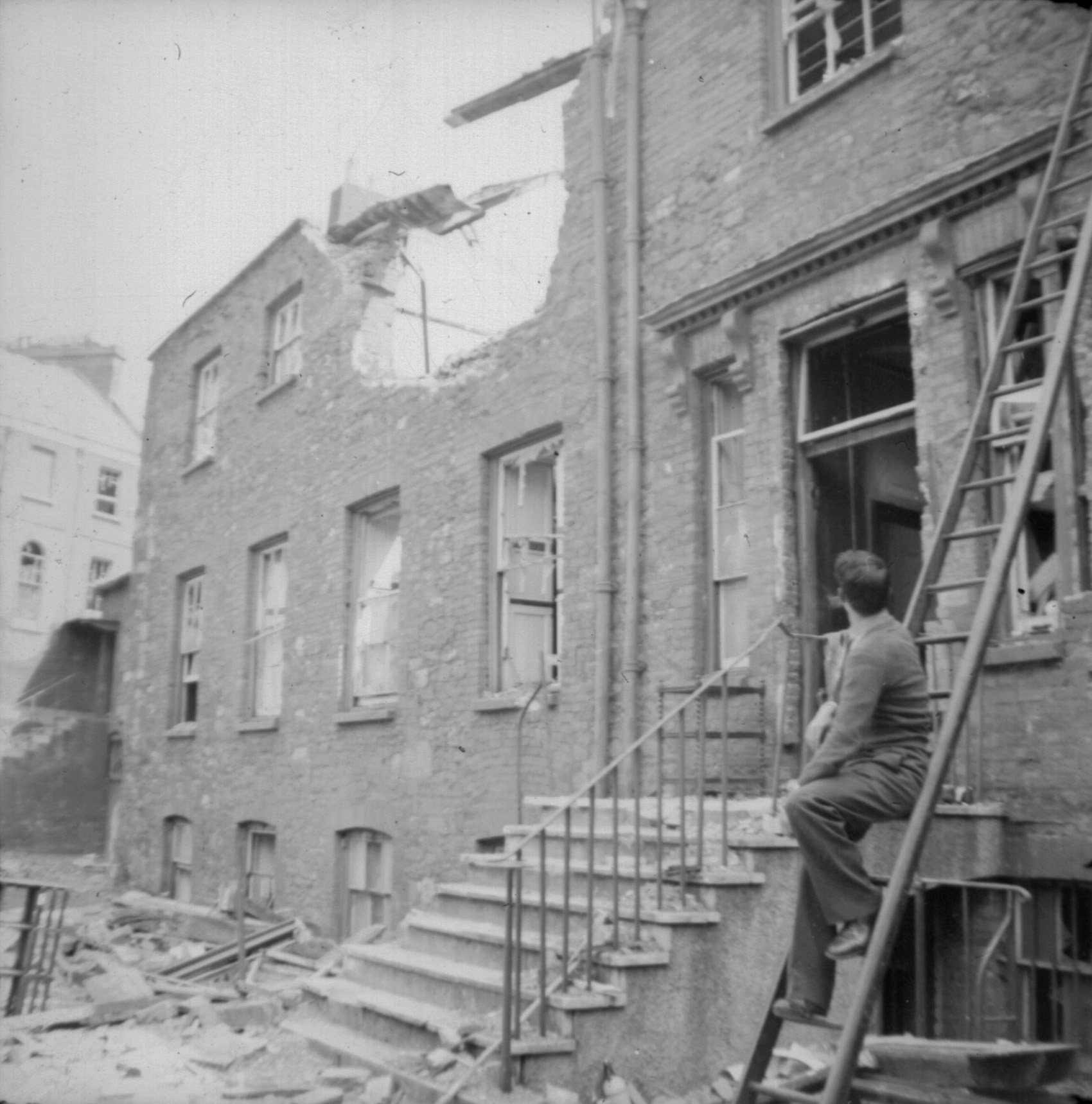 Ruined front of school with Michael Painter in foreground